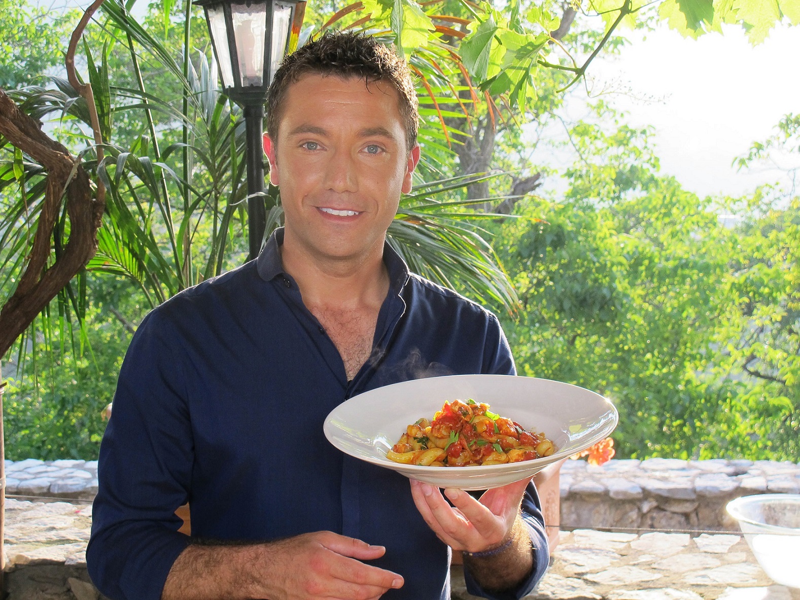 FROM ITV STUDIOS GINO'S ITALIAN ESCAPE Ep 5 Friday 11th October 2013 on ITV Pictured: Gino D'Acampo cooks GragnanoÕs legendary pasta with salmon in a spicy arrabbiata sauce in a corner of a orchard In episode five, Gino returns to his native Campania, the Italian region where he grew up and where his family still live. As a chef, he is eager to visit the town of Gragnano, which is world-famous for its pasta. Gino tours this unique place, where a combination of natural elements, sea breezes, hot sunshine and mountain water, have contributed to producing outstanding pasta. Our chef visits one of the townÕs historic pasta factories, where local ladies teach him the traditional skill of hand-rolling long fusilli. © ITV For further information please contact Peter Gray 0207 157 3046 peter.gray@itv.com This photograph is (C) ITV and can only be reproduced for editorial purposes directly in connection with the programme ITV. Once made available by the ITV Picture Desk, this photograph can be reproduced once only up until the Transmission date and no reproduction fee will be charged. Any subsequent usage may incur a fee. This photograph must not be syndicated to any other publication or website, or permanently archived, without the express written permission of ITV Picture Desk. Full Terms and conditions are available on the website www.itvpictures.com