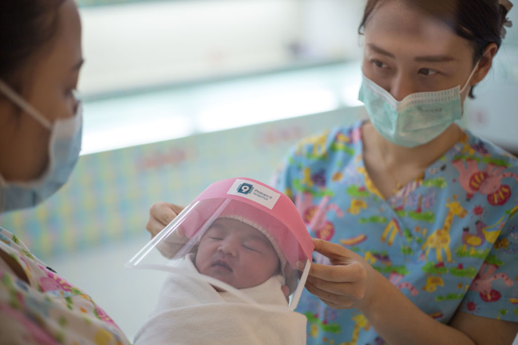 BANGKOK, THAILAND - APRIL 13: A nurse seen holding a new born baby wearing a tiny face shield against the coronavirus (COVID-19) pandemic at Praram 9 Hospital on April 13, 2020 in Bangkok, Thailand. Thailand's Health Ministry recorded a total of 2,579 infections, 40 death and 1,288 recovered since the beginning of the outbreak. (Photo by Guillaume Payen/Anadolu Agency via Getty Images)